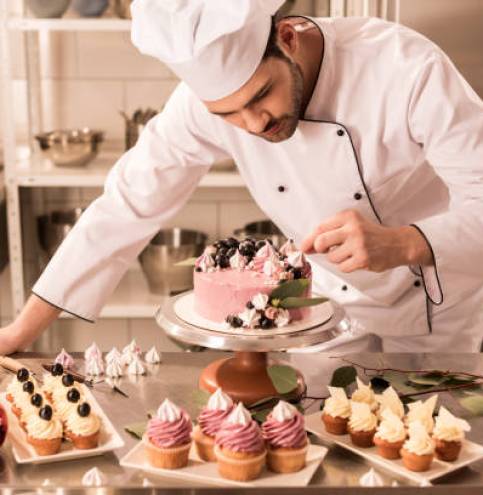 portrait of confectioner decorating cake in restaurant kitchen
